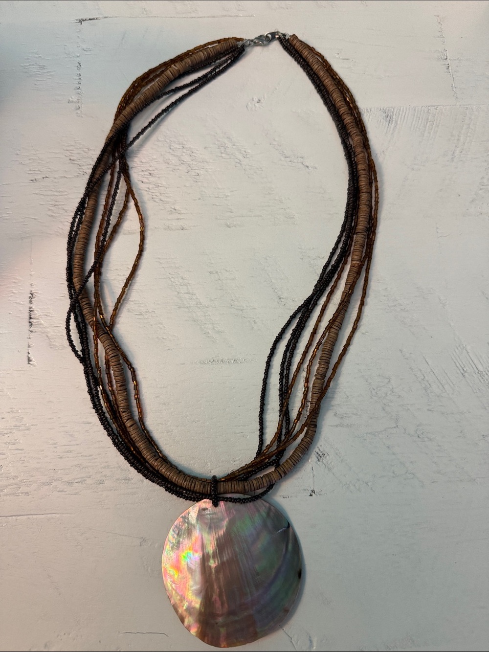 Multi-Strand Brown Beaded Necklace with Iridescent Shell Pendant